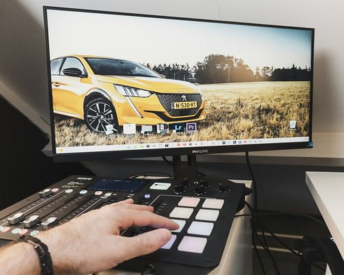 A person adjusting the brightness of a desktop monitor in an office